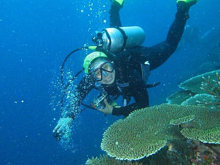 Diver blowing bubbles over a table coral reef