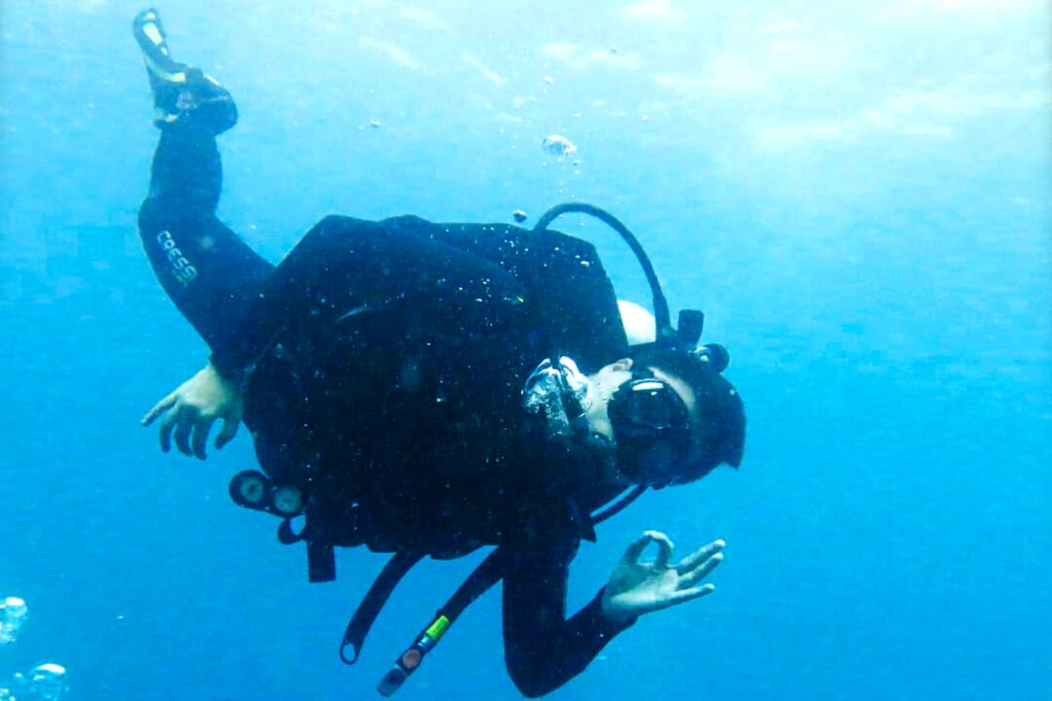 Nakula diver giving the OK sign in blue water